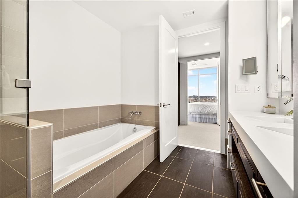 1820 Peachtree Road Northwest, Unit 905 Atlanta, GA 30309 - Photo 21 of 41 a bathroom with a tub sink and mirror