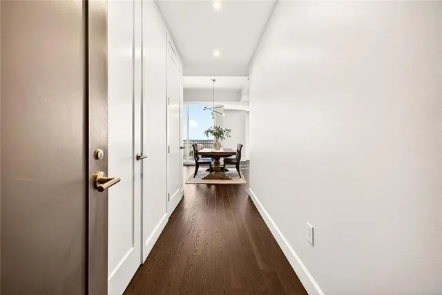 a view of a hallway with wooden floor and furniture