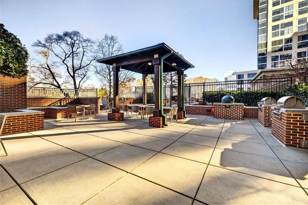 1820 Peachtree Road Northwest, Unit 905 Atlanta, GA 30309 - Photo 39 of 41 a view of a patio with couches and table and chairs with wooden floor