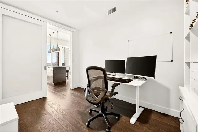a view of a workspace with furniture and wooden floor
