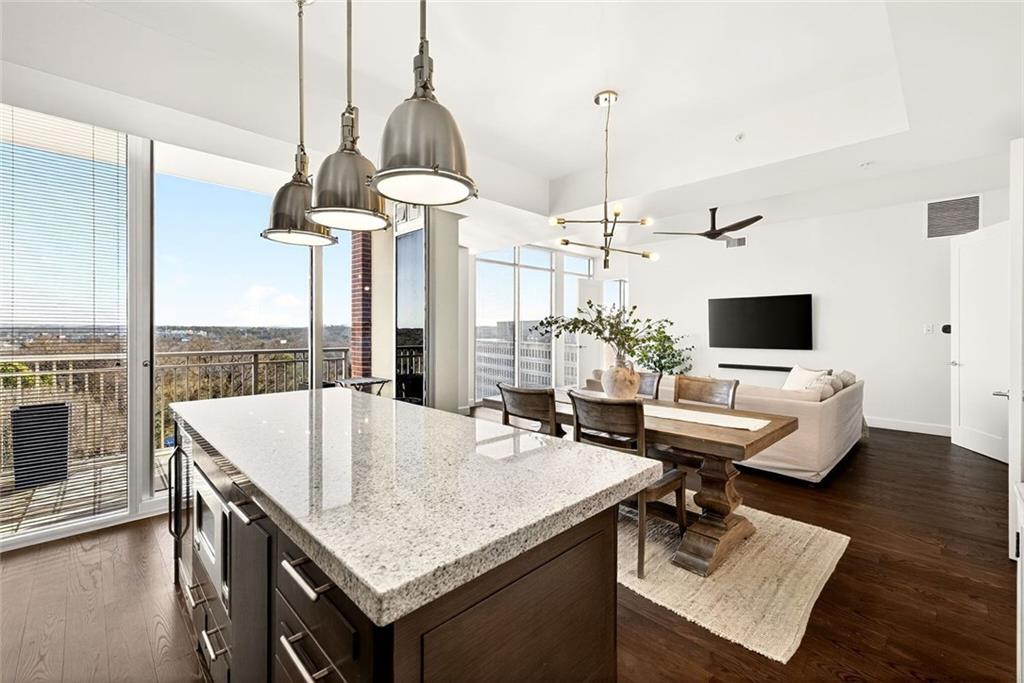 1820 Peachtree Road Northwest, Unit 905 Atlanta, GA 30309 - Photo 9 of 41 a living room with a table chairs and a wooden floor