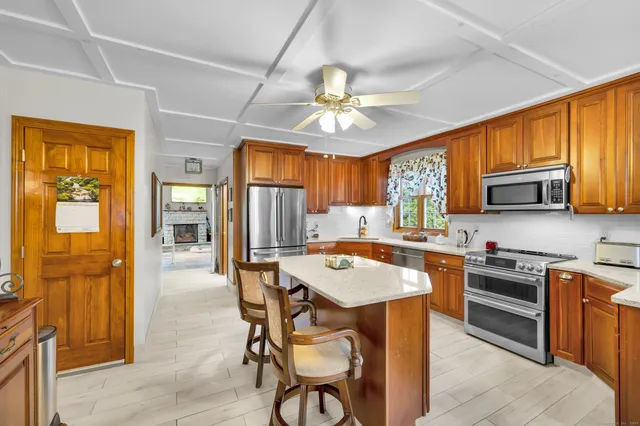 a large kitchen with a table chairs refrigerator and cabinets