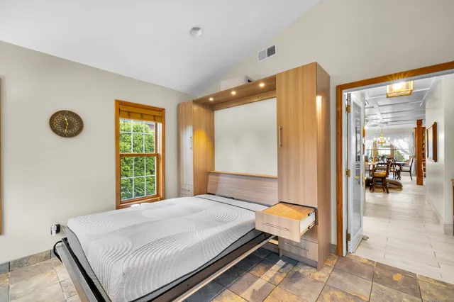 a spacious bedroom with a bed and a large window