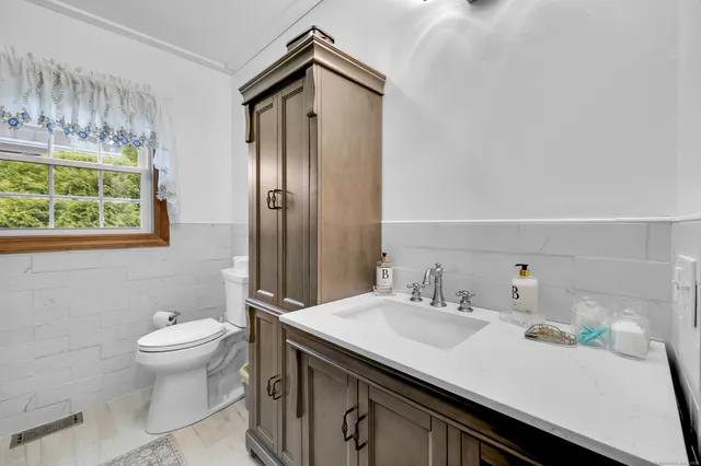 a bathroom with a sink a toilet and a mirror