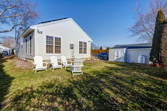 a backyard of a house with table and chairs