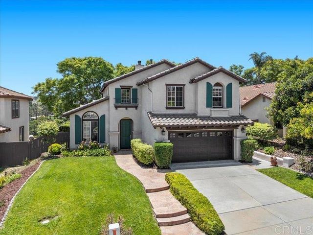 a front view of a house with a yard and potted plants