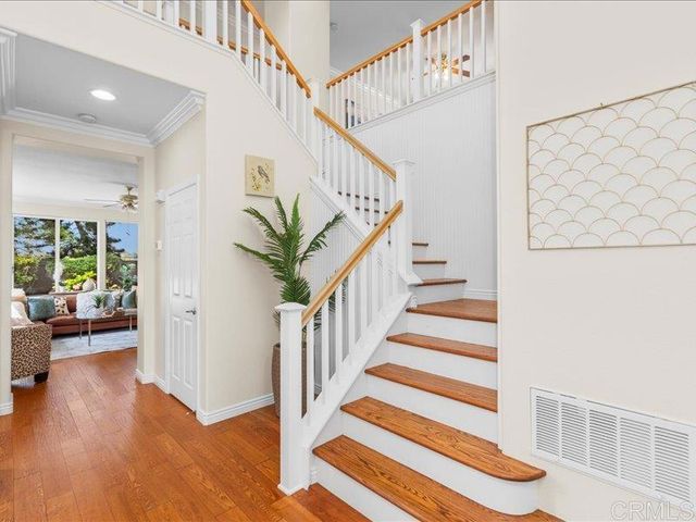 a view of a hallway with wooden floor and windows