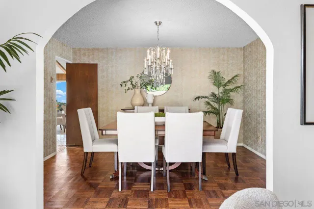 a dining room with furniture potted plants and wooden floor
