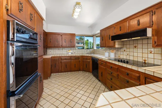 a kitchen with stainless steel appliances a sink cabinets and wooden floor