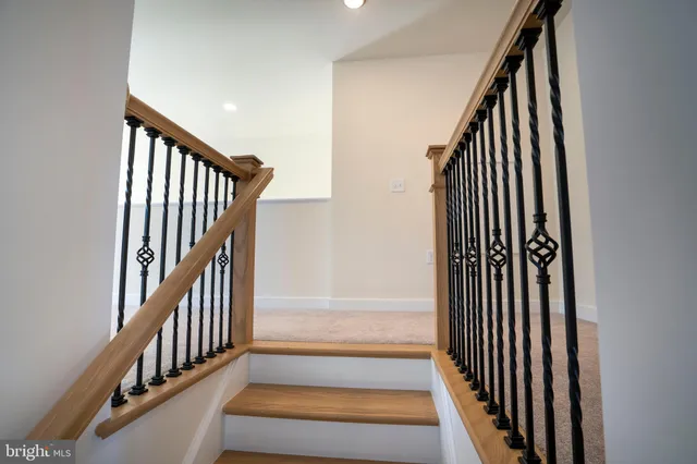 a view of hallway with stairs and wooden floor