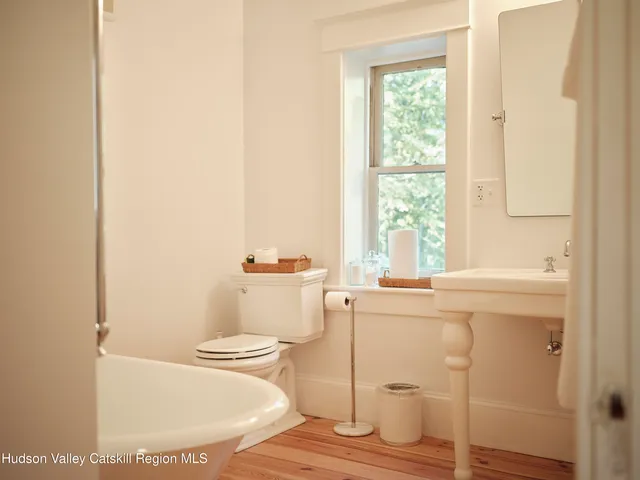 a bathroom with a sink toilet and window