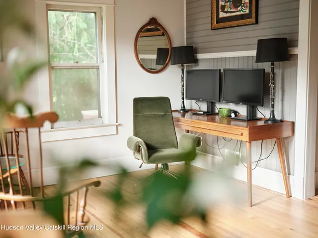 a work room with furniture and a floor to ceiling window