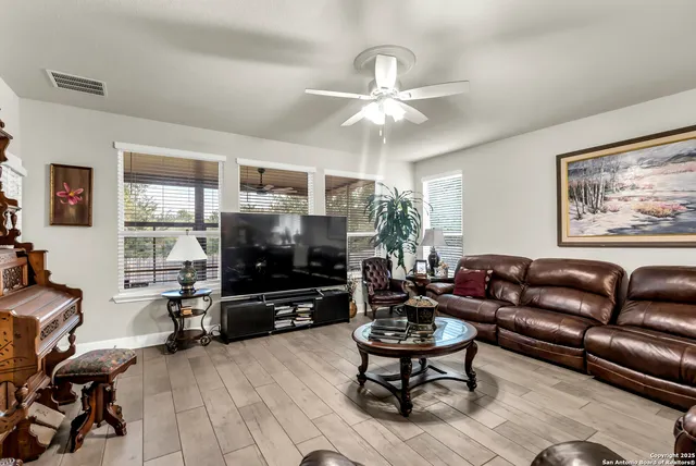 a living room with furniture a dining table and a flat screen tv with wooden floor