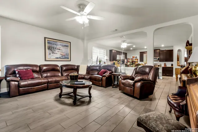 a living room with furniture ceiling fan and a rug