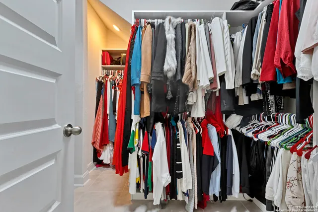 a view of walk in closet with clothes