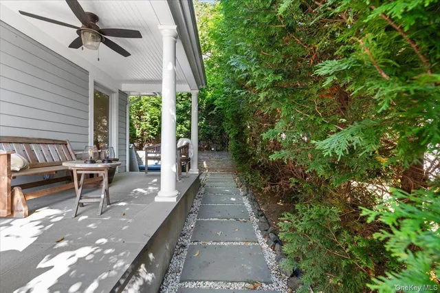 a view of a patio with table and chairs and floor to ceiling window