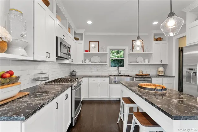 a kitchen with stainless steel appliances granite countertop a sink stove and refrigerator