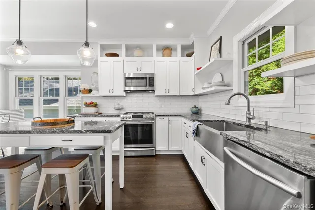 a large kitchen with stainless steel appliances granite countertop a sink and cabinets