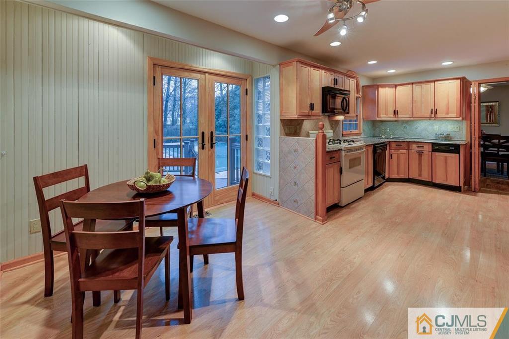52 Hillsdale Road Edison, NJ 08820 - Photo 11 of 25 a kitchen with stainless steel appliances kitchen island granite countertop a table chairs sink and cabinets