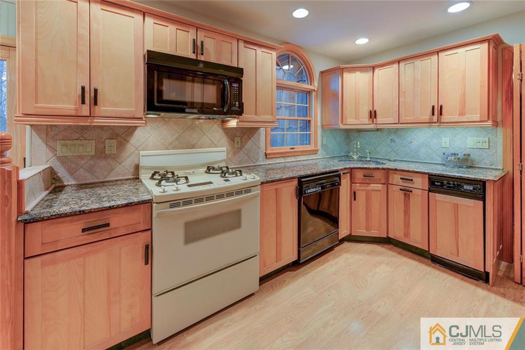 52 Hillsdale Road Edison, NJ 08820 - Photo 9 of 25 a kitchen with stainless steel appliances granite countertop a stove a sink and a microwave