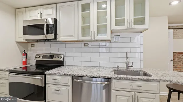 a kitchen with stainless steel appliances granite countertop a stove and a microwave