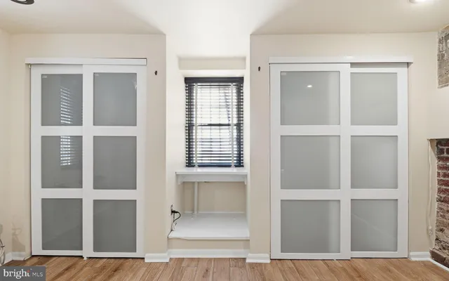 a view of an empty room with cabinet and door