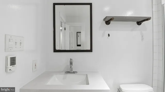 a bathroom with a toilet sink and mirror