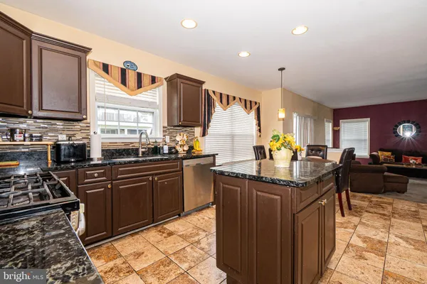 a kitchen with stainless steel appliances granite countertop a sink stove and cabinets