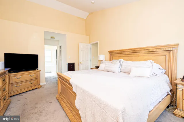 a spacious bedroom with a bed and a flat screen tv