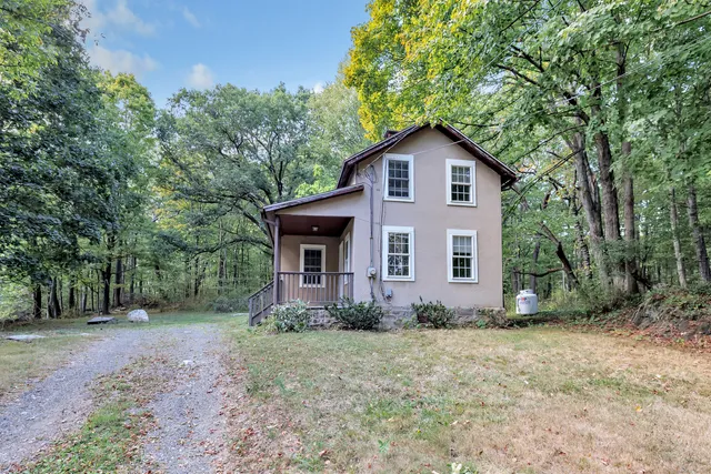a front view of house with yard and trees