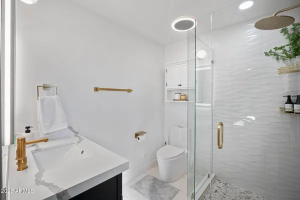 a bathroom with a sink a toilet and shower