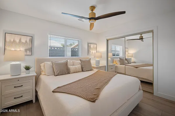 a bedroom with a large bed a chandelier and a window