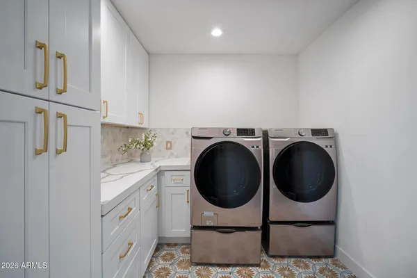 a utility room with sink dryer and washer