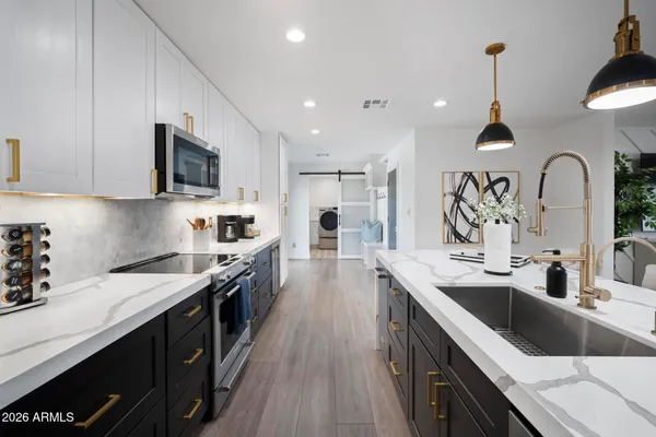 a kitchen with a sink stove top oven and cabinets