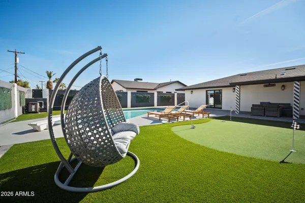 a swimming pool with outdoor seating and yard