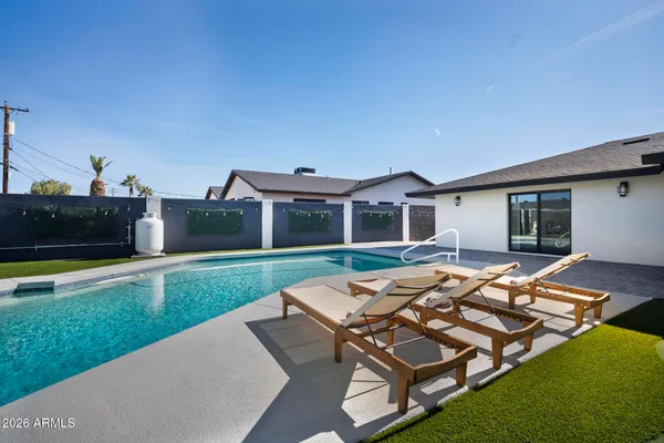 a view of a house with swimming pool and sitting area