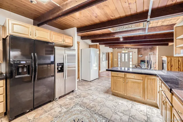 a kitchen with granite countertop a refrigerator and a sink