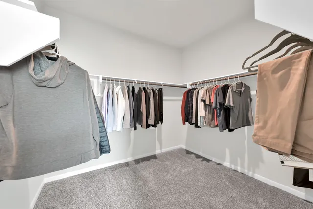 a view of walk in closet with clothes and shoes