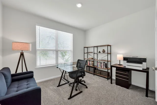 a view of a livingroom with workspace and a window
