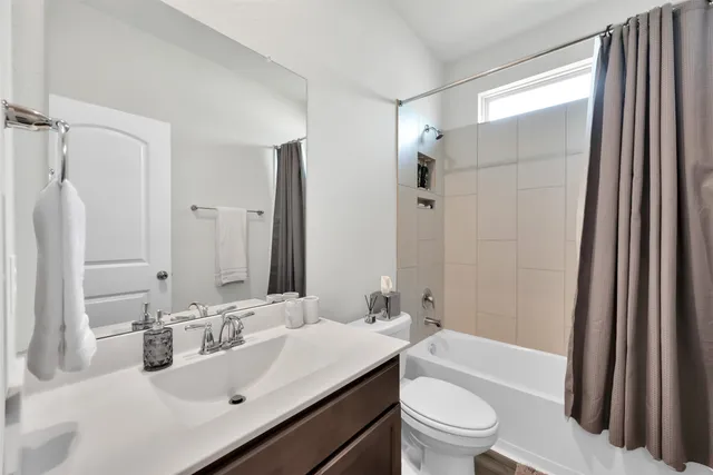 a bathroom with a sink a toilet a tub and shower