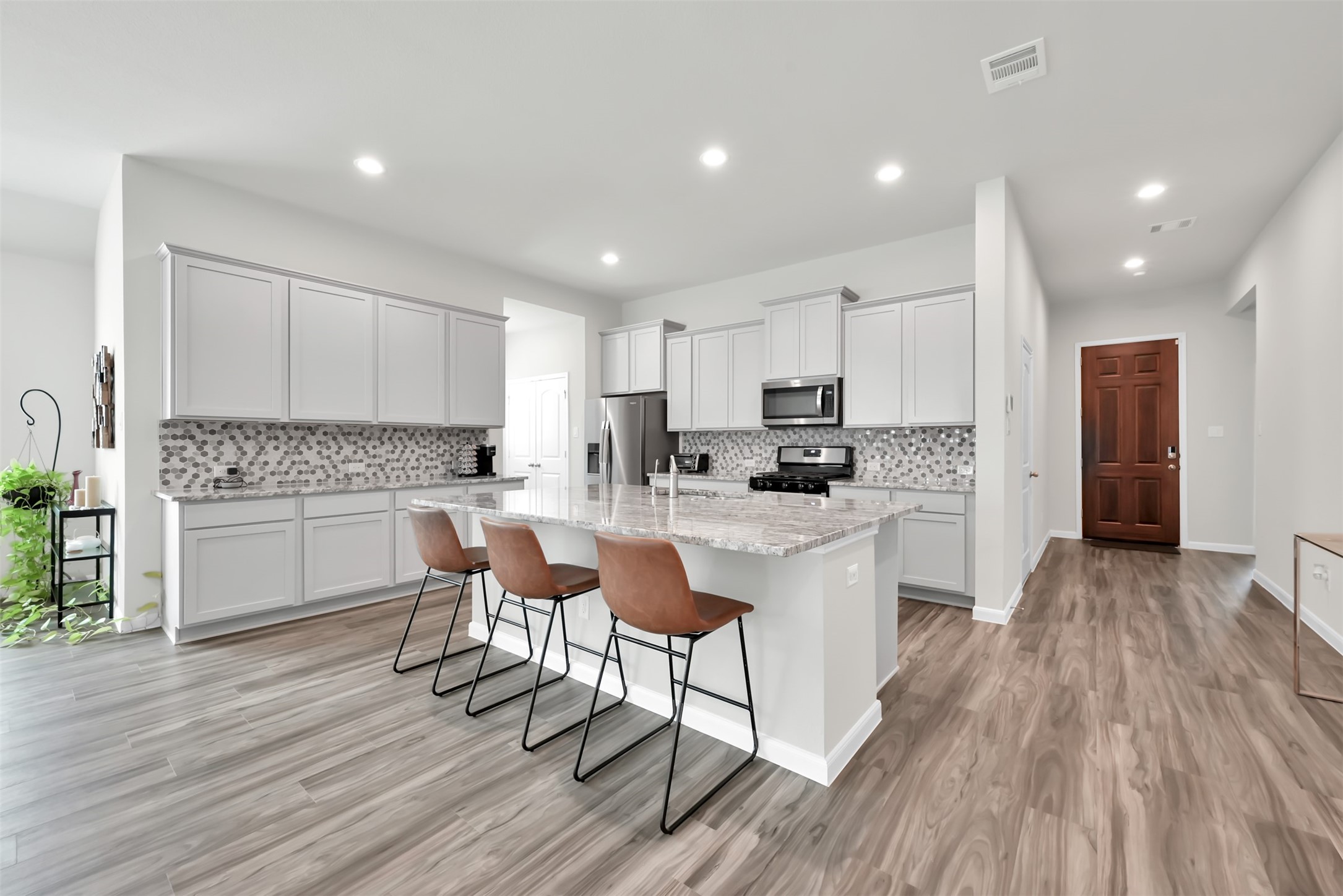 14243 Volcano Perch Drive Conroe, TX 77384 - Photo 2 of 25 This home features a beautiful kitchen which includes an abundance of cabinets, oversized island, gas stainless steel appliances, refrigerator INCLUDED and open to the dining area and living room