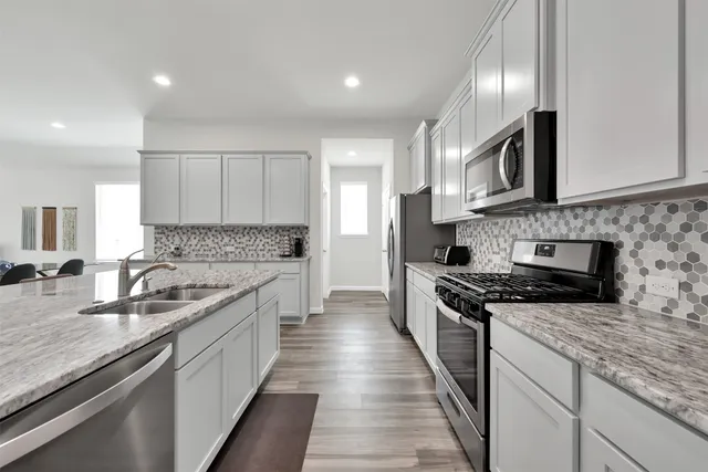a kitchen with stainless steel appliances granite countertop a sink stove and cabinets