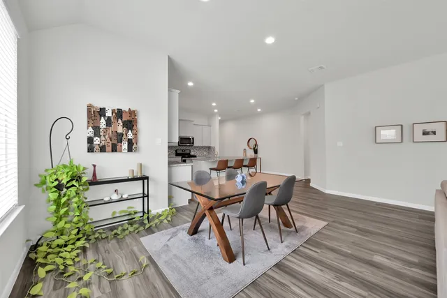 a dining room with furniture and wooden floor