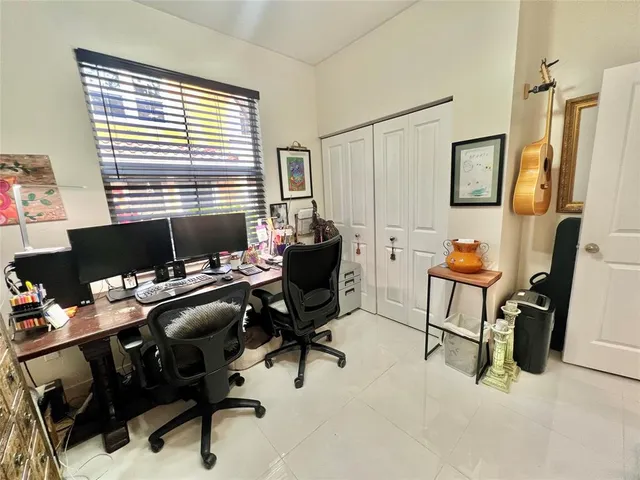 a view of a workspace with furniture and a window