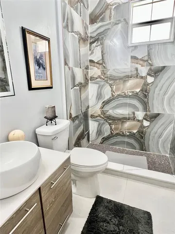 a white toilet sitting next to a bathroom sink
