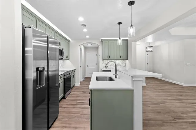 a kitchen with stainless steel appliances kitchen island a chandelier