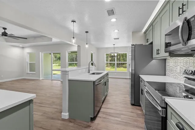 a large kitchen with stainless steel appliances granite countertop a sink and a stove