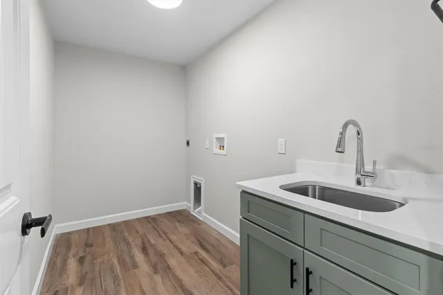 a close view of a sink and dishwasher with wooden floor