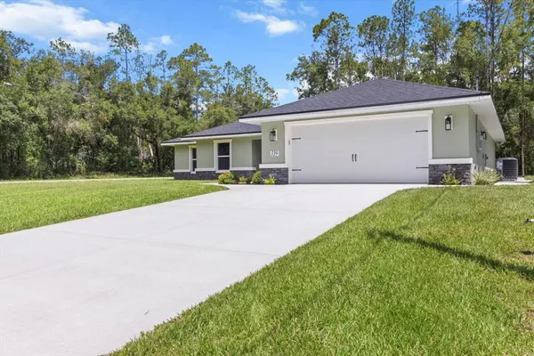 a front view of a house with a yard and trees