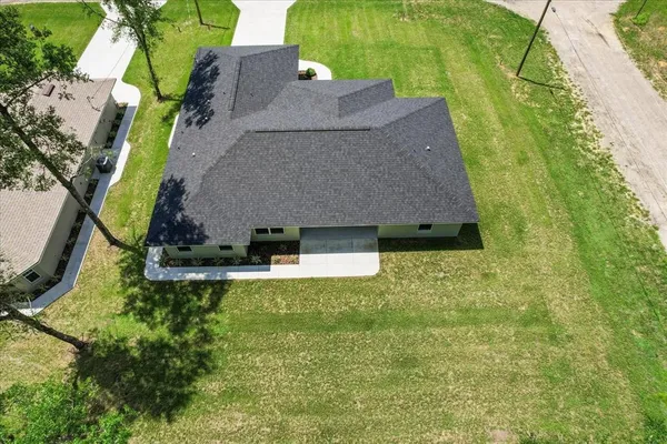 an aerial view of residential house with outdoor space and trees all around